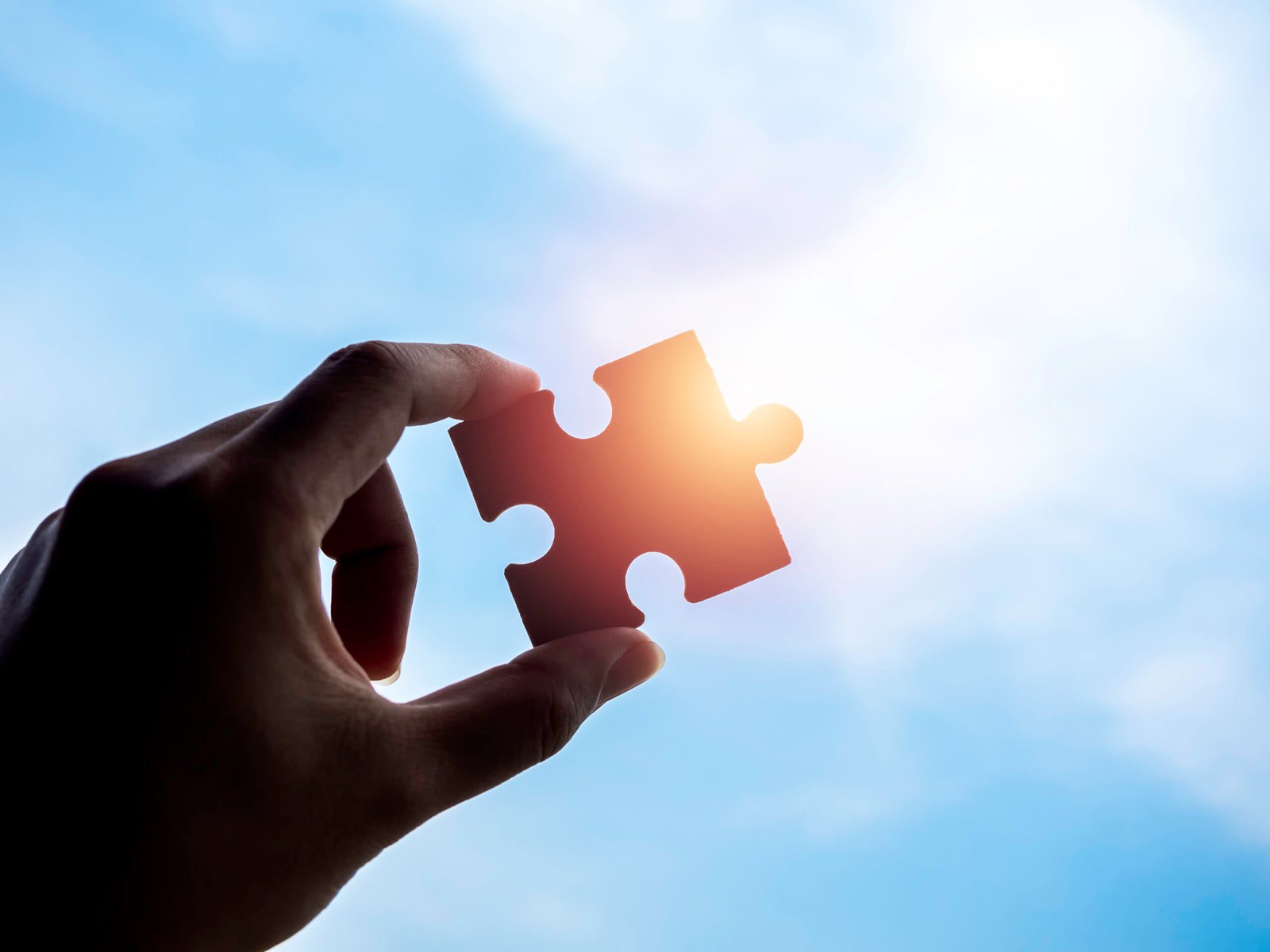 Jigsaw puzzle against blue sky background, silhouette.